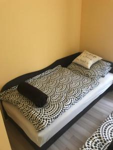 バラトンマーリアフュルドゥーにあるBalázs nyaralóházのベッド1台(白黒の毛布、枕付)