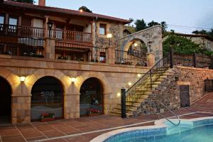 een gebouw met een zwembad en een huis bij Posada Valle del Oso in Lerones