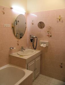 a bathroom with a sink and a tub and a mirror at Hostellerie le Clos du Cher in Noyers-sur-Cher