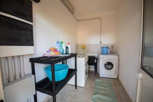 eine kleine Küche mit Waschmaschine, Waschmaschine und Trockner in der Unterkunft Villa Urania in Torre San Giovanni Ugento