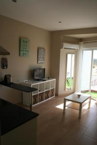 a living room with a table and a couch and a tv at CLB Feria Apartment in Seville