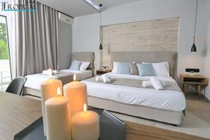 a bedroom with two beds with candles in it at Hotel Tropical in Hanioti +124 photos