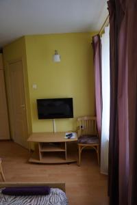 a room with a tv and a desk and a chair at Guesthouse Bērzi in Plācis