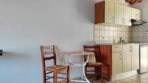 a kitchen with a table and chairs and a counter at Villa Maraki in Agia Paraskevi