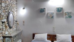 a bedroom with a bed and a mirror on the wall at Villa Maraki in Agia Paraskevi