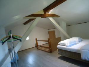 a attic room with a bed and a ladder at cottage pleine nature in Wattwiller