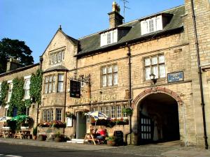 un antiguo edificio de piedra con un arco en una calle en The Teesdale Hotel, en Middleton in Teesdale