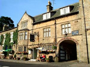 an old stone building with an archway in a street at The Teesdale Hotel in Middleton in Teesdale
