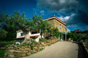 a house with a tree next to a stone wall at Paradiso verde a poca distanza dal mare in Agropoli
