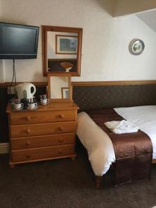 a bedroom with a television and a bed at The Molly House in Blackpool
