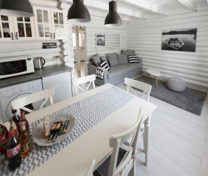 cocina y sala de estar con mesa blanca y sillas en Öböl Liget vendégházak, en Abádszalók