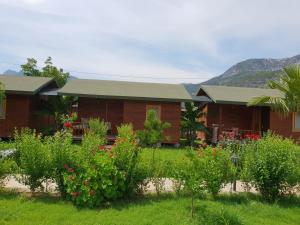 a building with a bunch of flowers in a yard at Estelar Bungalow in Cıralı