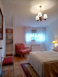 a bedroom with a bed and a chair and a chandelier at Pilar Villanueva in Bueu