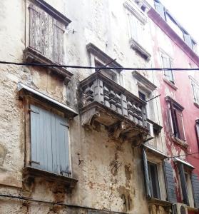 an old building with a balcony on the side of it at EXCELSIOR Apartments Rovinj in Rovinj