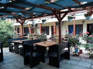 una mesa de madera y sillas bajo una pérgola de madera en Camere de închiriat Doriana, en Vama Veche