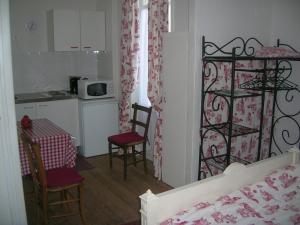 バニョール・ドゥ・ロルヌにあるStudette Villa Odetteのキッチン、ベッドルーム(ベッド1台、テーブル、椅子付)