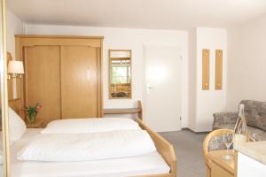 ein Hotelzimmer mit einem Bett und einem Stuhl in der Unterkunft Schönblick Hotel Garni Ferienwohnungen in Lindenberg im Allgäu