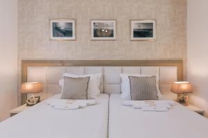 a bedroom with a large white bed with two lamps at Villa Royal Apartments in Tivat