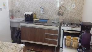 una pequeña cocina con fogones y fregadero en Casa da Celia, en Arraial do Cabo
