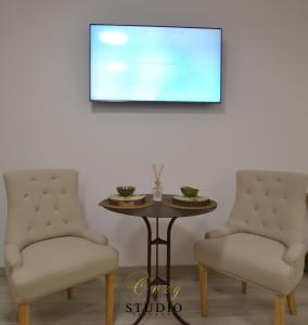 two chairs and a table with a picture on the wall at Cozy Studio Alicante in Alicante