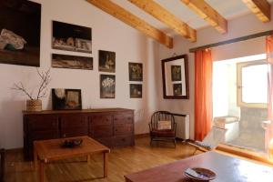 uma sala de estar com uma cómoda e uma mesa em Apartamento en casa del s.XVI em Trujillo