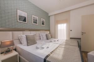 a bedroom with a large white bed in a room at Villa Royal Apartments in Tivat