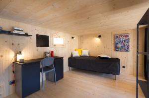 a bedroom with a bed and a desk in a room at Refuges en ville in Bourg-Saint-Maurice
