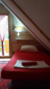 a bedroom with a red bed with a red blanket at Vacation home SAJRA in Kulen Vakuf