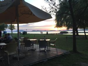 バラトンレッレにあるAnna Villa Balatonlelleの木製デッキ(テーブル、椅子、パラソル付)