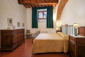 カレンツァーノにあるAgriturismo Fattoria di Sommaiaのベッドルーム1室(緑のカーテンと窓付きのベッド1台付)