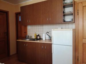 una cucina con frigorifero bianco e armadietti in legno di Pokoje u Marysi a Łeba