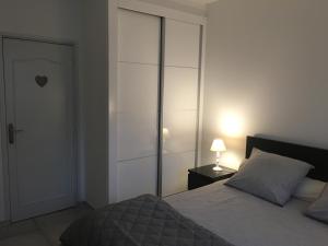 ラ・モットにあるAu 165 Un havre de paixのベッドルーム1室(ベッド1台、ドア、ランプ付)