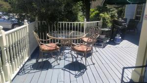 a glass table and four chairs on a deck at Port Albert Inn and Cottages in Port Albert