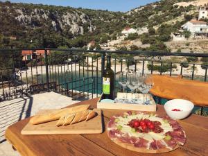 a table with a bottle of wine and a plate of food at Villa Kristina in Sevid