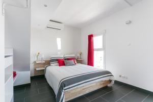 a bedroom with a large bed with red curtains at Luxury Penthouse in Naturiste; FKK, Nudist Village in Cap d'Agde
