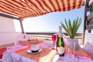 a table with a bottle of wine on top of it at Luxury Penthouse in Naturiste; FKK, Nudist Village in Cap d'Agde