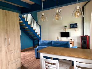 a living room with a blue couch and stairs at Playas de Luarca in Barcia