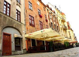 una calle con sombrillas frente a un edificio en Milky Way Szczytna, en Toruń