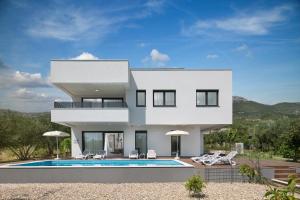 Villa Diana في قشتيلا: بيت ابيض وامامه مسبح