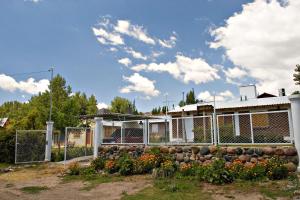 a fence in front of a building with flowers at Cabañas Orión in Potrerillos