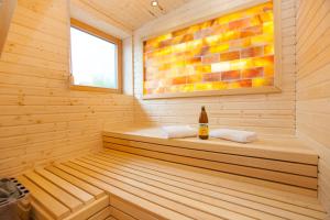 una sauna de madera con una botella de vino. en Residenz Cheval am Pfaffenberg Friedrichshafen Messe, en Oberteuringen