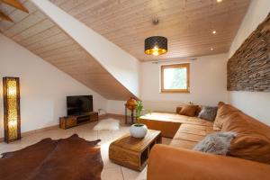 a living room with a couch and a tv at Residenz Cheval am Pfaffenberg Friedrichshafen Messe in Oberteuringen