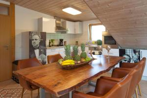 a kitchen with a wooden table with a bowl of fruit on it at Residenz Cheval am Pfaffenberg Friedrichshafen Messe in Oberteuringen +15 photos