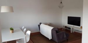 a living room with a couch and a table and a tv at Monte Clérigo - Aljezur - Apartamento T2 in Aljezur