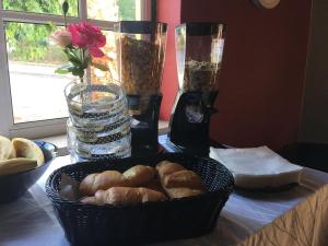 a basket of pastries on a table with two vases at Residencial Gil Vicente in Sardoal