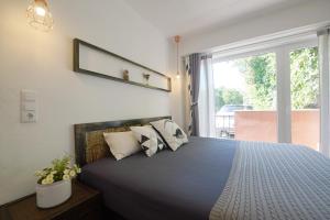 a bedroom with a bed with pillows and a window at Lei Home in Cascais