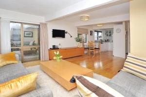 a living room with a couch and a table at Salisbury Apartment - Christchurch Holiday Homes in Christchurch