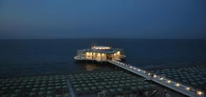 a pier with a building on the water at night at CASA CALI' in Senigallia