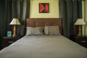 a bedroom with a large bed with two lamps at Jamaica Shades @ Cool Shades in Priory