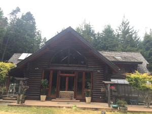 Cette cabane en rondins dispose d'une grande fenêtre et de portes. dans l'établissement Redwood forest, à Crescent City